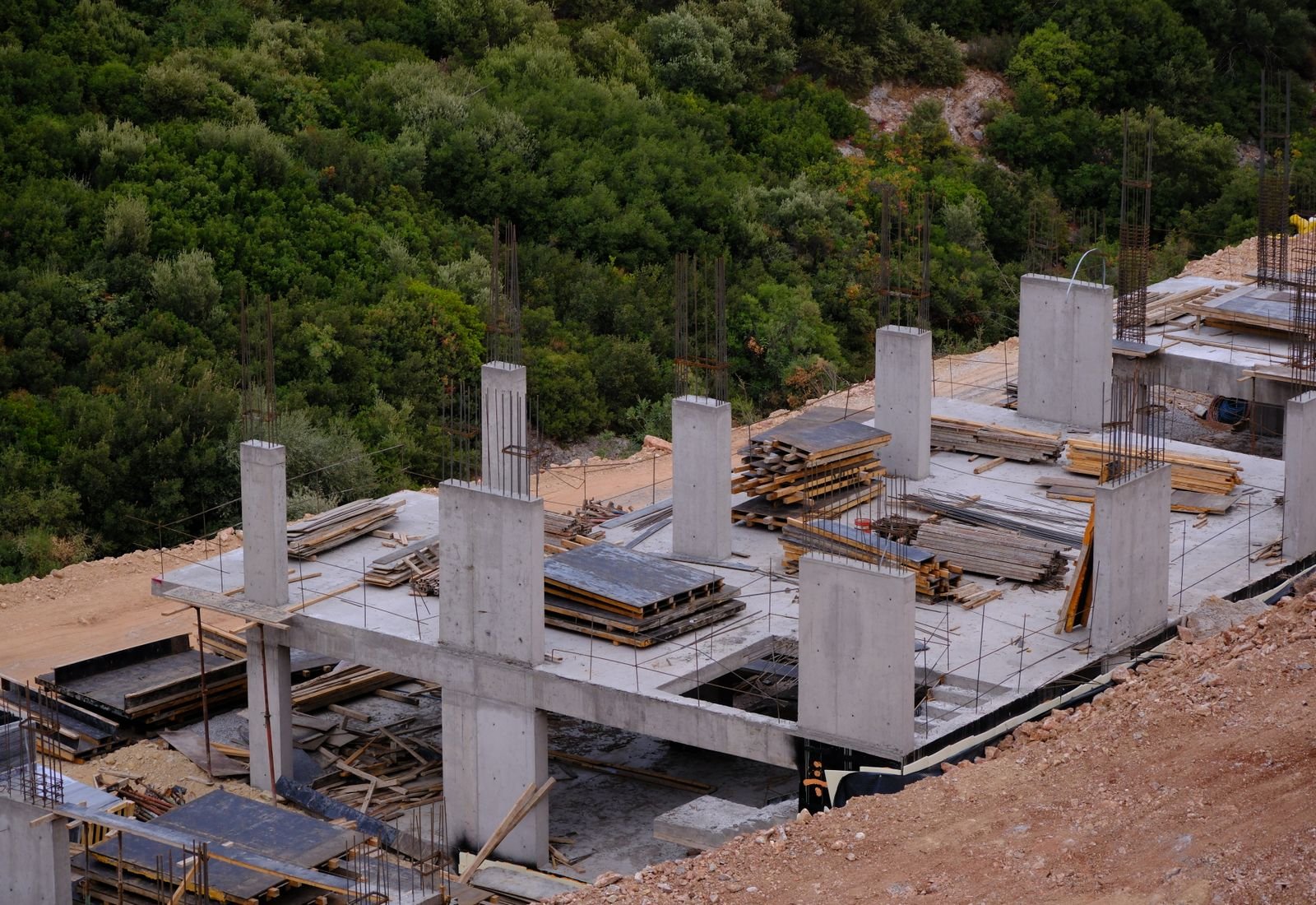 Concrete foundation at a construction site surrounded by trees